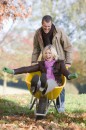 Man pushing wife in wheelbarrow